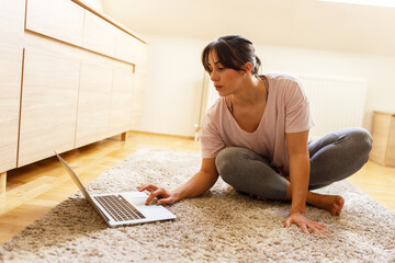 Mid-age woman doing yoga and morning exercise in her bedroom.	