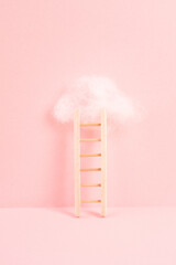 Ladder with a cloud on top, pink rose colored background, copy space, dreaming of success, creative...