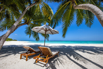 Beautiful tropical island scenery, two sun beds, loungers, umbrella under palm tree. White sand,...