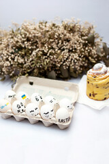 White eggs in a tray painted for Easter in support of Ukraine against the war, cruffin and flowers