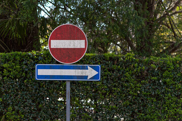 One-way street signs and blue arrow in Italy.