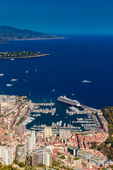 Aerial view of port Hercules of Monaco at sunset, Monte-Carlo, huge cruise ship is moored in marina, view of city life from La Turbie mountain, a lot of mega yachts and boats