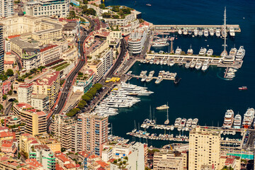Aerial view of port Hercules of Monaco at sunset, Monte-Carlo, huge cruise ship is moored in marina, view of city life from La Turbie mountain, a lot of mega yachts and boats