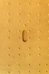 Metal texture with rows of rivets painted yellow. Bright and light back.