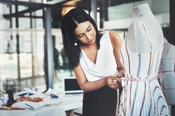 Ill have to take a few inches off. Shot of a successful young fashion designer working on her...