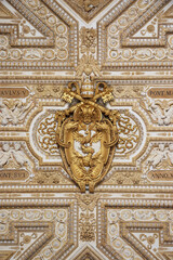 White and gold antique decorative baroque detail with golden eagle, keys and Papal tiara