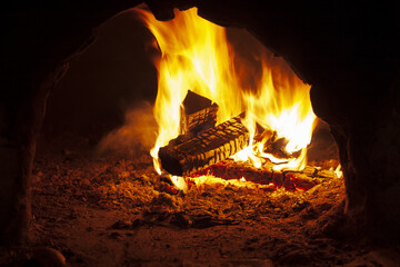 Flaming wood in an open oven, burning firewood in a fireplace