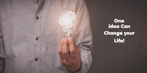 man holding bulb with gear icon showing idea symbol