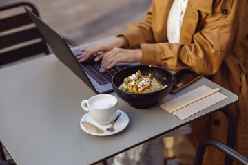 Close-up of woman hand typing something on laptop
