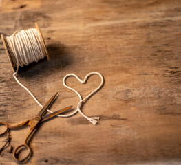 Heart-shaped thread spool with rusty scissors on one side with space for text, logo, brand... 