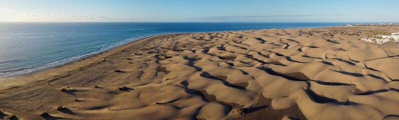 Aerial drone landscape of Maspalomas golden sand dunes at sunrise, Gran Canaria, Canary Islands, Spain