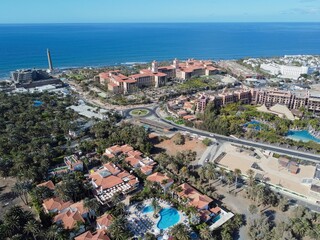Aerial drone. Popular resort town of Meloneras, with hotels and restaurants, near the Maspalomas dunes in Gran Canaria, Canary Islands, Spain