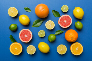Flat lay of citrus fruits like lime, orange and lemon with lemon tree leaves on light colored background. Space for text healthy concept. Top view
