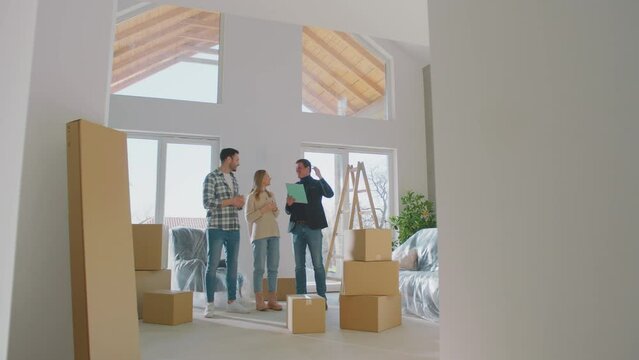 A realtor showing new stylish luxurious  house to caucasian couple. Couple visiting the apartment for buying purpose