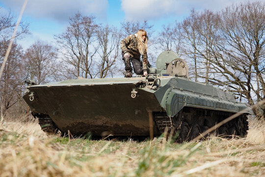 eine frau in milit&auml;rkleidung steht auf einem russischen panzer mit der bezeichnung bmp