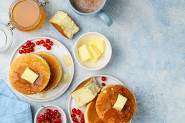 Fluffy Japanese Souffle pancakes with honey, butter and red currants  on a white plates. Asian dessert for breakfast. Top view