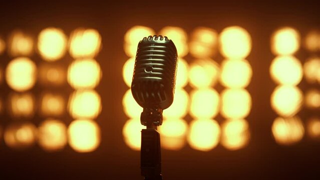Retro mic placed empty scene illuminated lamps close up. Microphone in nightclub