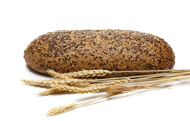 Integral wheat bread loaf with seeds and ear wheat isolated on white  