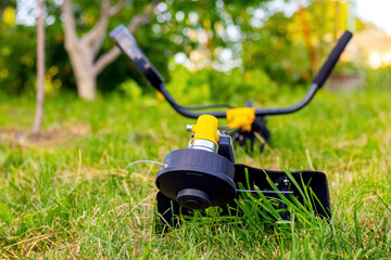 Trimmer for mowing the grass in the garden among the thick grass