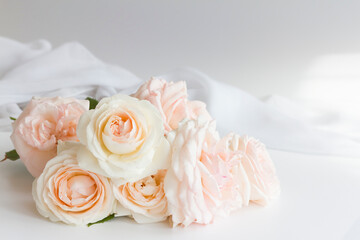 Bouquet of vintage romantic roses in pastel watercolor tones on a gray and white background.white silk in the rays of the sun 