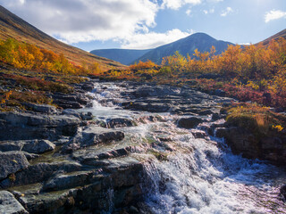 Beautiful mountain waterfall among rocks in polar summer in Khibiny Mountains. Kola Peninsula, Arctic, polar summer
