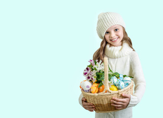 Smiling little girl with basket full of colorful easter eggs