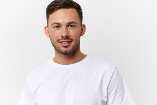 Cheerful cute happy young tanned handsome man in basic t-shirt smile at camera posing isolated on over white studio background. Copy space Banner Mockup. People emotions Lifestyle concept. Portrait