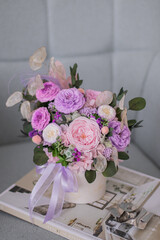 Beautiful spring bouquet in pink and purpl color, in round ceramic vase. Arrangement with Peonies roses. Decorative flowers in a round vase.