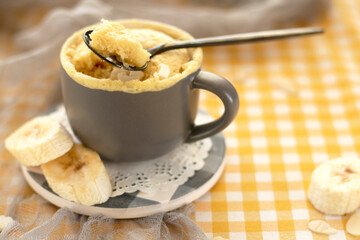 selective focus. homemade Portioned Banana bread mugcake in small mugs. Easy sweet baking in the microwave idea, With fresh bananas, nuts. Muffin with banana slices cooked in a mug. copy space. 