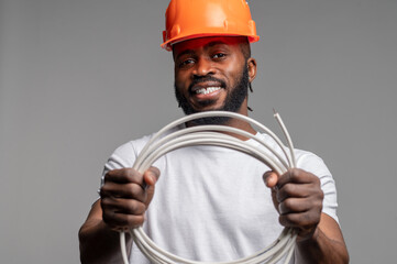 Engineer in an orange helmet demonstrating a rubber-sheathed electrical wire