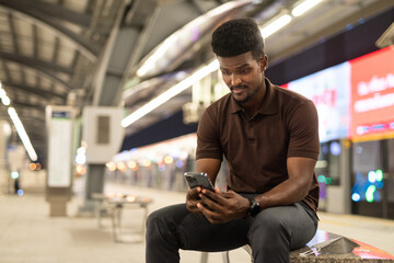 Fototapeta na wymiar Portrait of handsome black man at train station during night