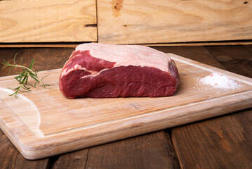 piece of sirloin, rosemary and salt on bamboo cutting board