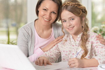 mother and daughter using laptop