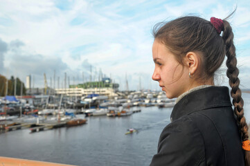 Fototapeta na wymiar Girl tourist on the background of the yacht club in Tallinn in autumn