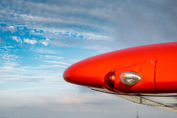 Landing lights on the wingtip close-up. Red wing of a light aircraft against the sky. The concept...