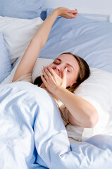 the girl woke up on a bright sunny day in a blue bed. the concept of good morning. awakening....