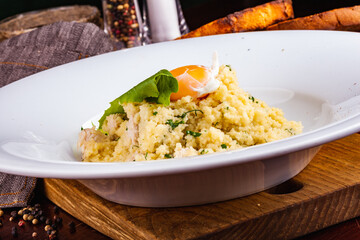 Couscous with chicken and egg on a white plate