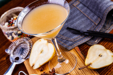 Pear cocktail in martini glass on wooden table. Close up