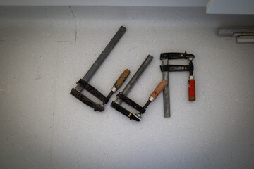 3 screw clamps lie next to each other on the floor