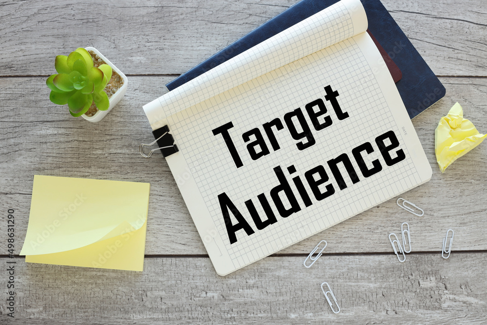 Poster target audience text on an open notebook on an envelope with money. next to a potted plant
