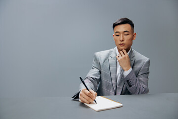 worker in a gray suit in the office with a notepad on the table the idea of writing Lifestyle