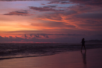 Fototapeta na wymiar silhouette of a couple walking on the beach
