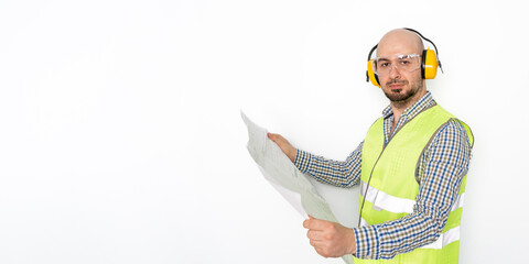 Engineer with protective headphones holding blueprint. White background