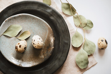 Easter table setting with eggs and green branch. Holidays background