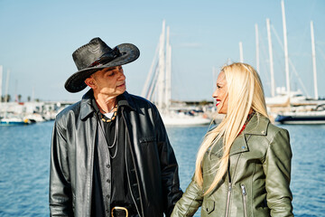 Fototapeta premium Romantic middle-aged couple strolling along the harbor