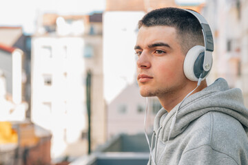 young man with headphones listening to music on the street