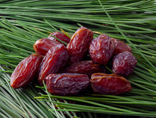 Juicy date fruit selective focus on a green pine leaf. The most consumed fruit in Ramadan