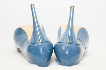 Blue sexy high-heeled shoes on a white carpet.