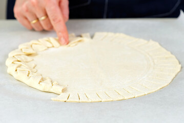 Pizza making process. Top view of pizza dough base. Home-baking pizza with a braided pie crust. close up