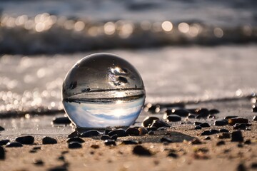 Abstract holiday seaside idea. Sea landscape held in a glass ball with a blurred background.